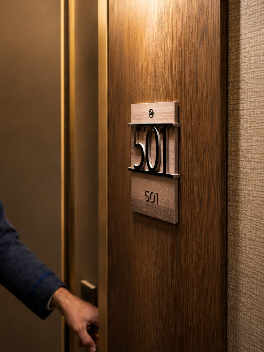 Guest room entry at the Aiden, with Art Deco room numerals in walnut and bronze